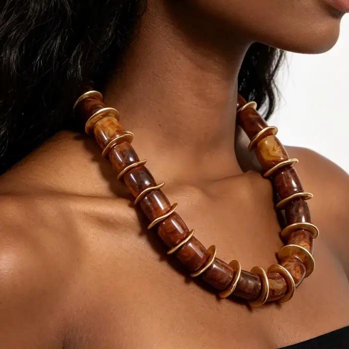 Collier ras du cou cylindrique en résine avec disques d'espacement dorés ondulés irréguliers, chaîne d'extension réglable et motif tourbillon terrestre audacieux