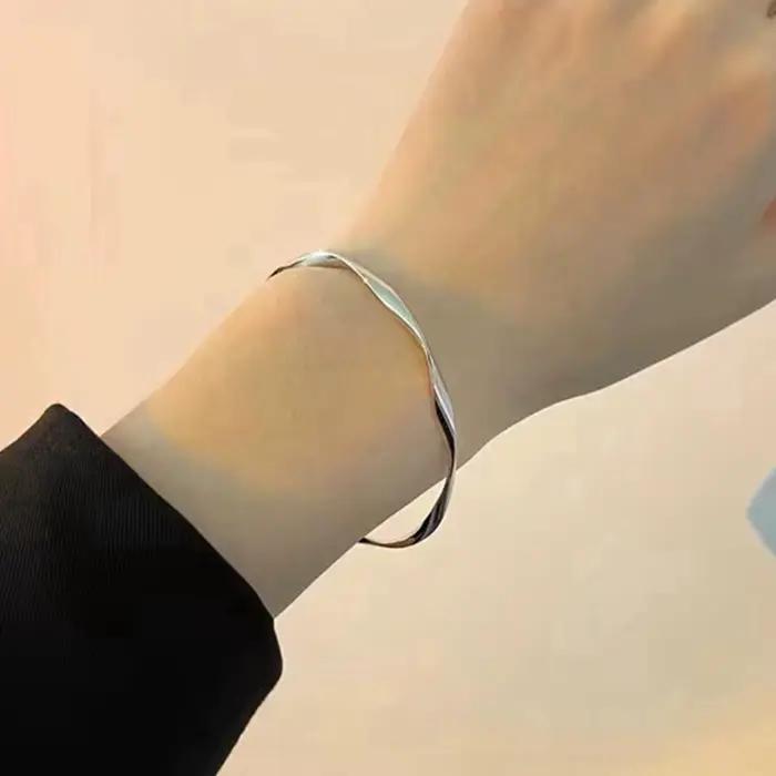 Un bracelet pour femme avec ouverture torsadée, réglable, simple et polyvalent, adapté à un usage quotidien