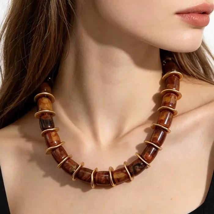 Collier ras du cou cylindrique en résine avec disques d'espacement dorés ondulés irréguliers, chaîne d'extension réglable et motif tourbillon terrestre audacieux