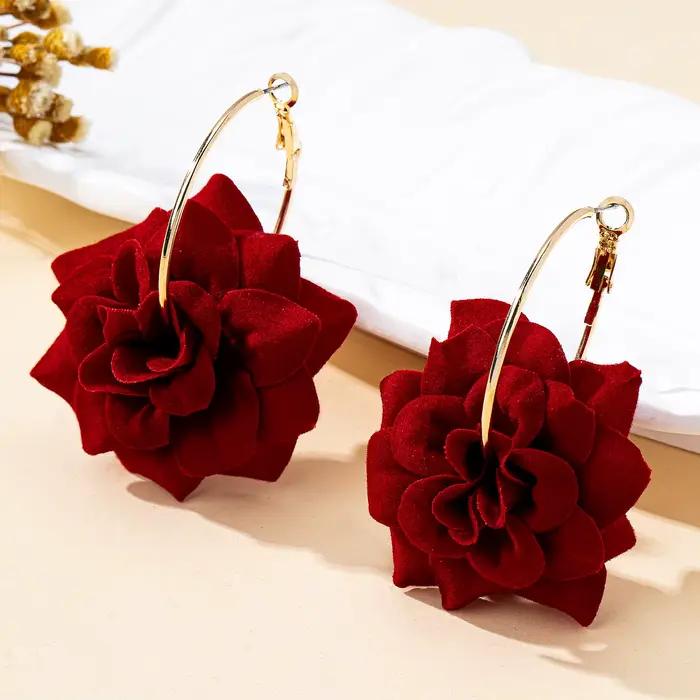 Une paire de boucles d'oreilles créoles pour femme avec fleurs en tissu tridimensionnelles rouges, idéales pour le quotidien et les vacances