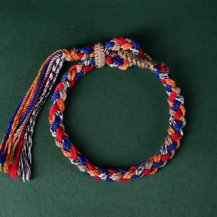 Bracelet en corde de coton tressée tibétaine fait main avec pompon – Bijou ethnique bohème pour la foi spirituelle