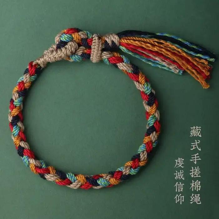 Bracelet en corde de coton tressée tibétaine fait main avec pompon – Bijou ethnique bohème pour la foi spirituelle