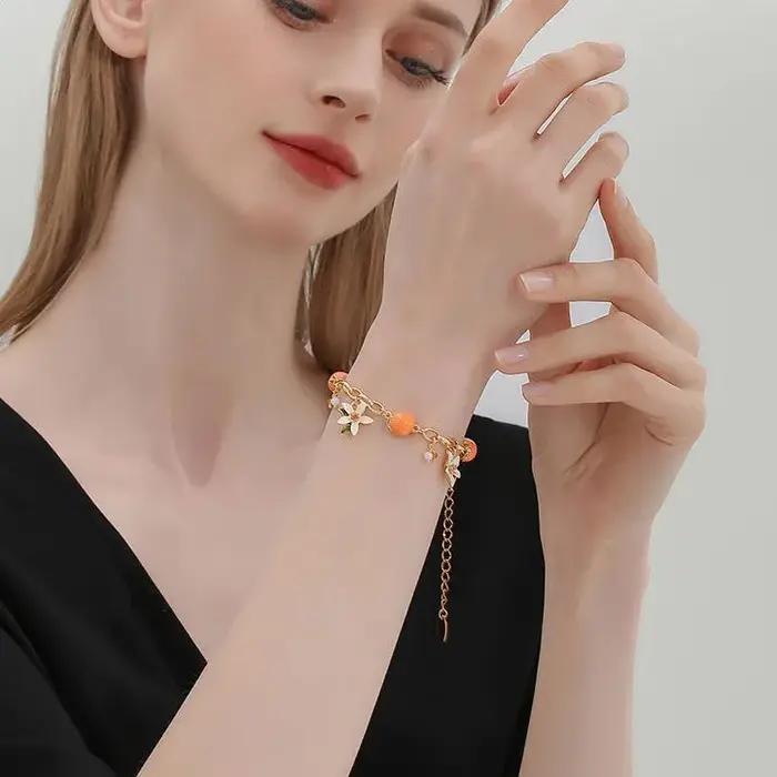 Bracelet en acrylique et cuivre style fleur orange douce pour femme occassions estivales fraicheur douceur naturelle style élégant