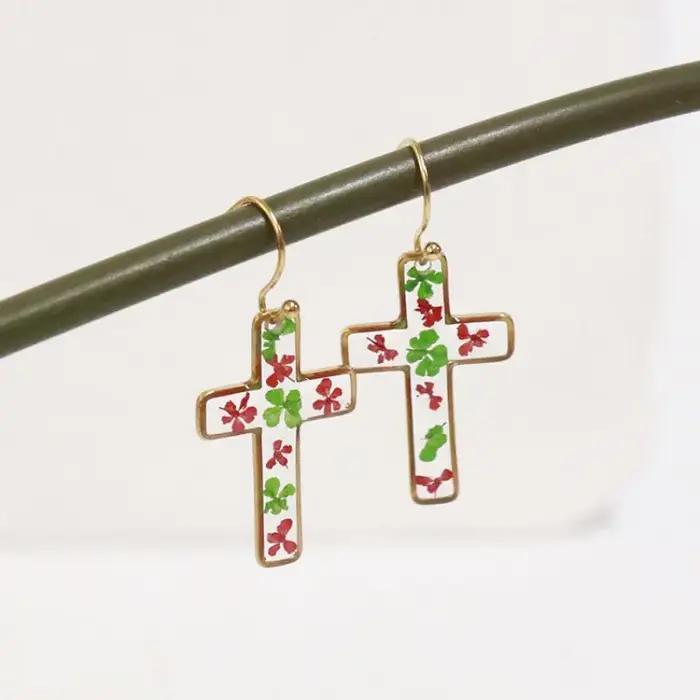 Boucles d'oreilles en résine époxy avec fleurs pressées de la série The Cross