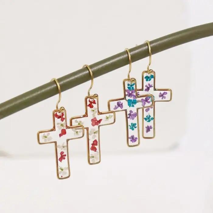 Boucles d'oreilles en résine époxy avec fleurs pressées de la série The Cross