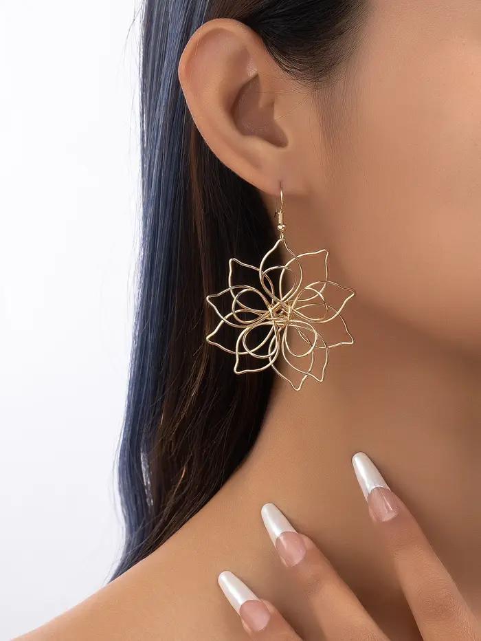 Une paire de boucles d'oreilles à fleurs en fer tridimensionnelles creuses à la mode et polyvalentes pour femmes