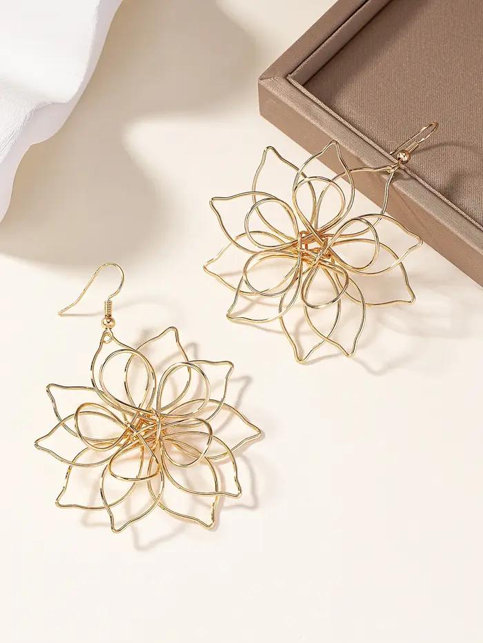 Une paire de boucles d'oreilles à fleurs en fer tridimensionnelles creuses à la mode et polyvalentes pour femmes