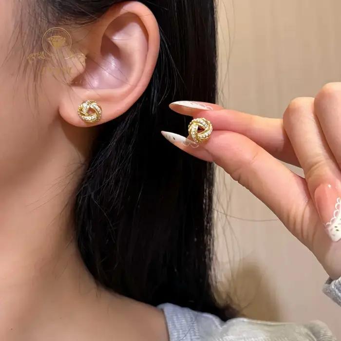 Boucles d'oreilles clous triangulaires entrelacées serties de diamants