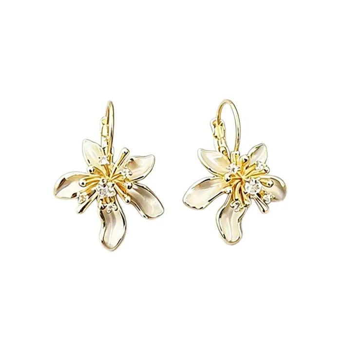 Élégantes boucles d'oreilles pendantes en émail blanc avec fleur