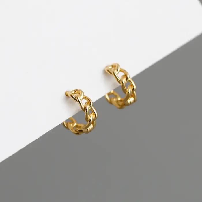 Une paire de boucles d'oreilles en chaîne géométrique simples et à la mode, vitrine un charme person