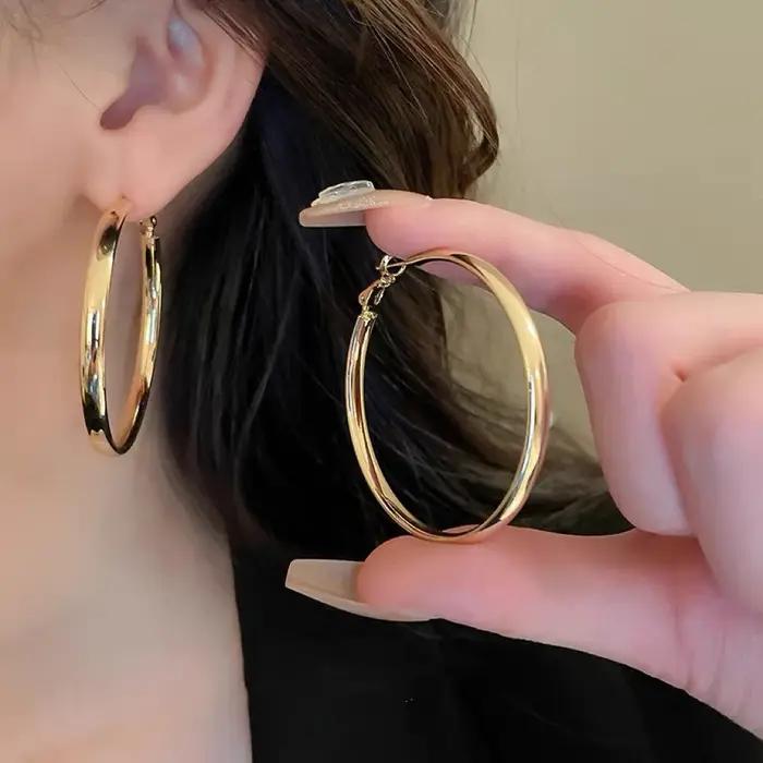 Grandes boucles d'oreilles plates à la mode pour femmes