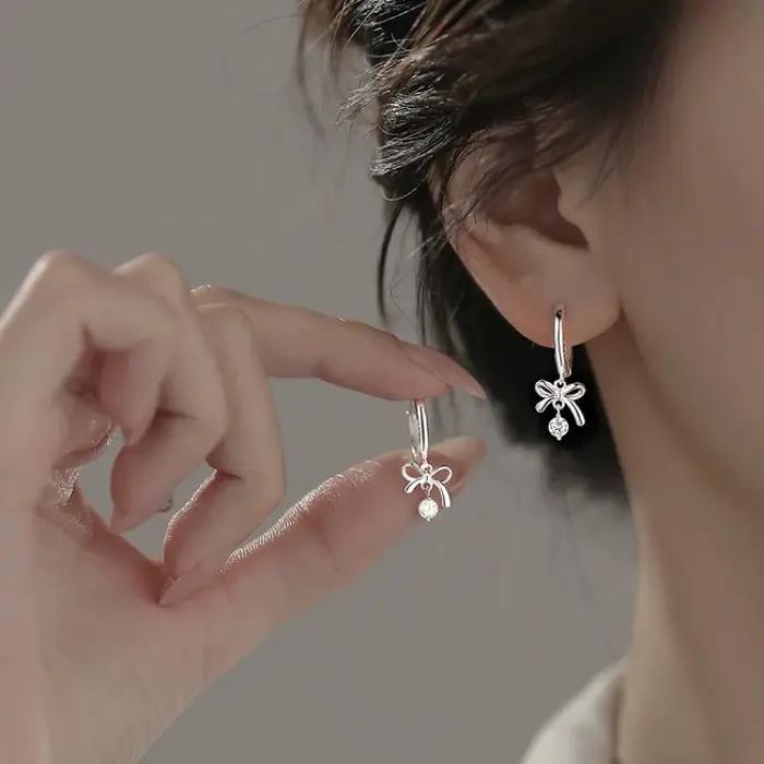 Cette exquise boucle d'oreille en forme de papillon incurvée avec pompon est en argent 925 et est un bijou haut de gamme.