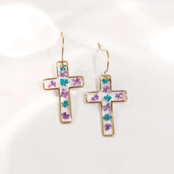 Boucles d'oreilles en résine époxy avec fleurs pressées de la série The Cross