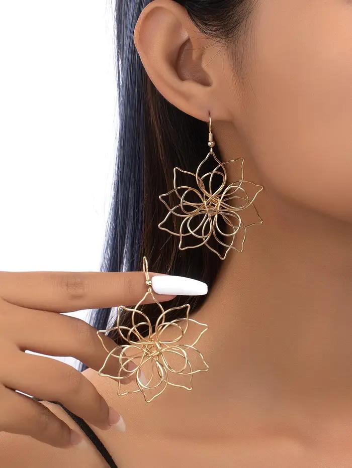 Une paire de boucles d'oreilles à fleurs en fer tridimensionnelles creuses à la mode et polyvalentes pour femmes