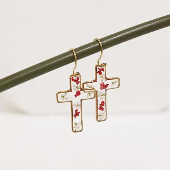Boucles d'oreilles en résine époxy avec fleurs pressées de la série The Cross